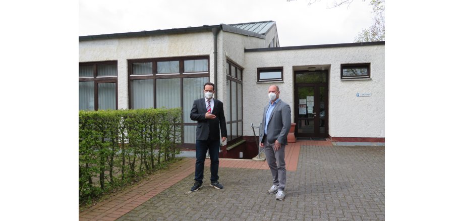 Vor dem Eingang des Testzentrums stehen Bürgermeister Michael Köhler und André Brübach.